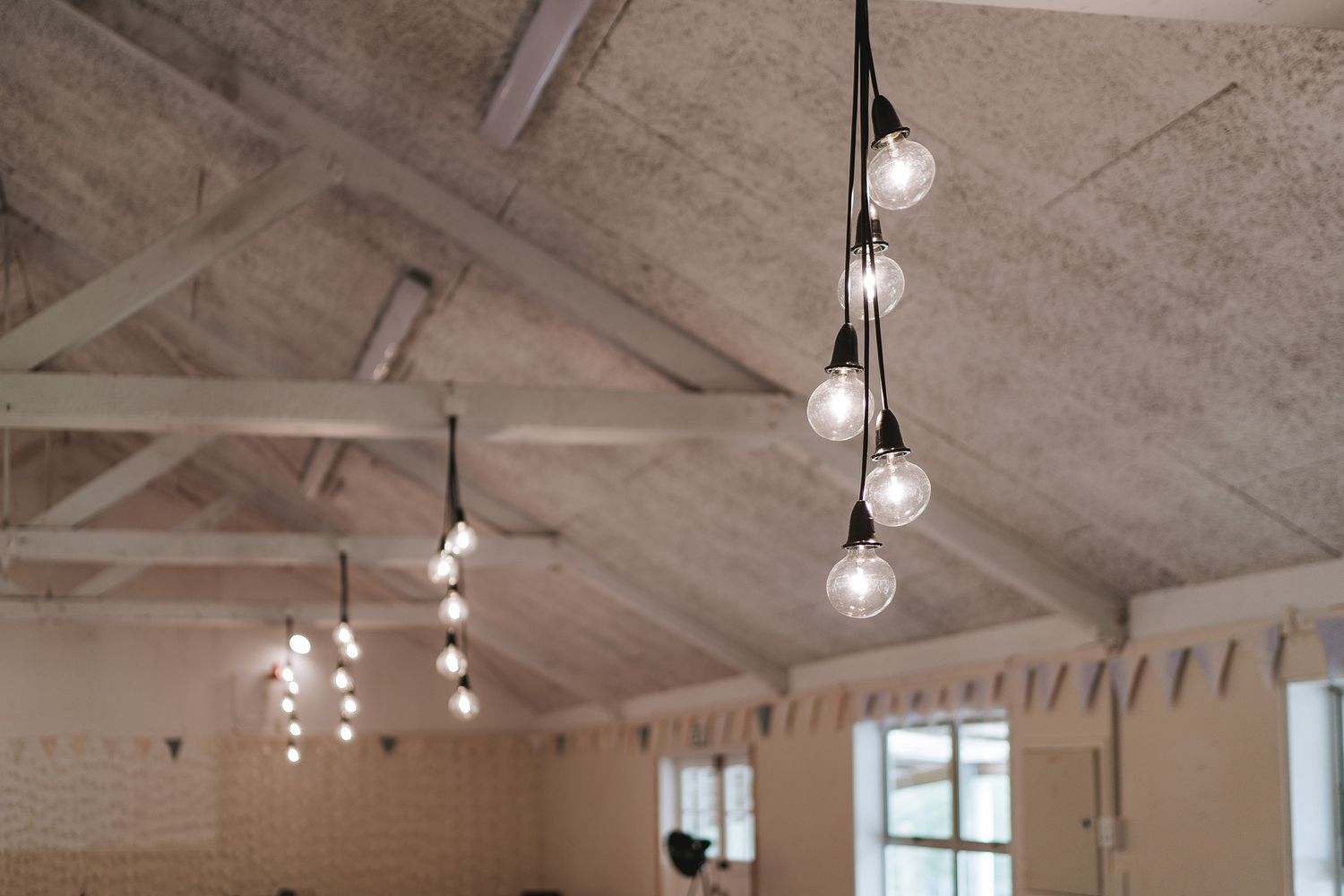 Industrial-style ceiling with exposed beams and track lighting fixtures creates a modern rustic ambiance.