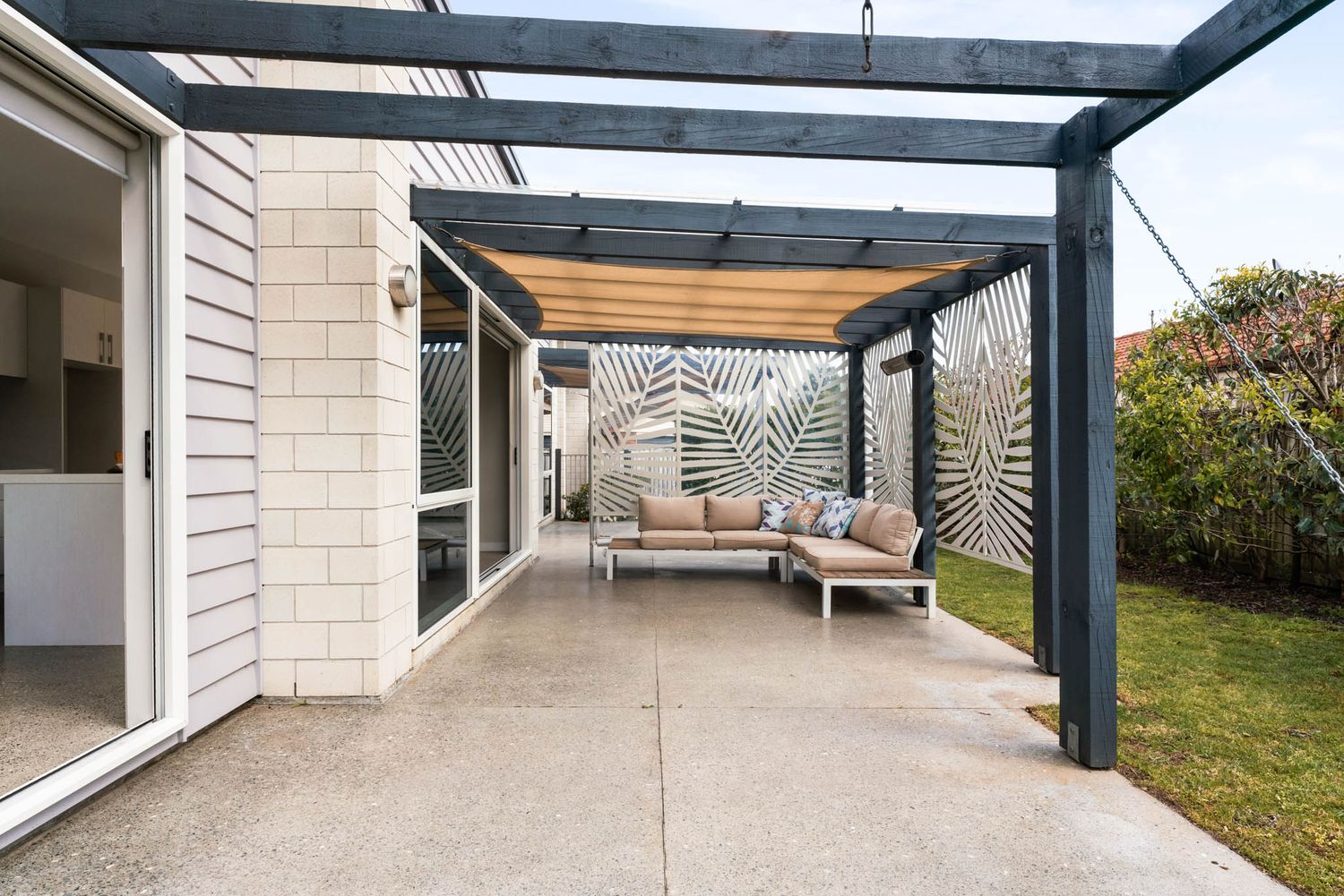 Covered patio with modern pergola and comfortable outdoor seating area.