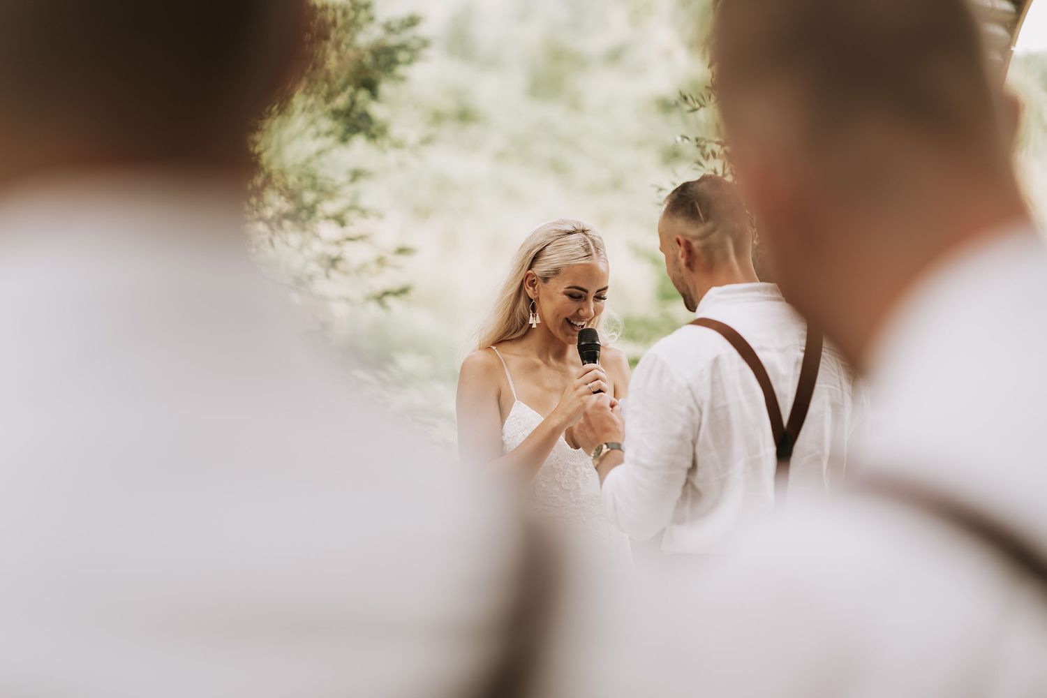 A joyful moment between newlyweds exchanging vows during an outdoor wedding ceremony.