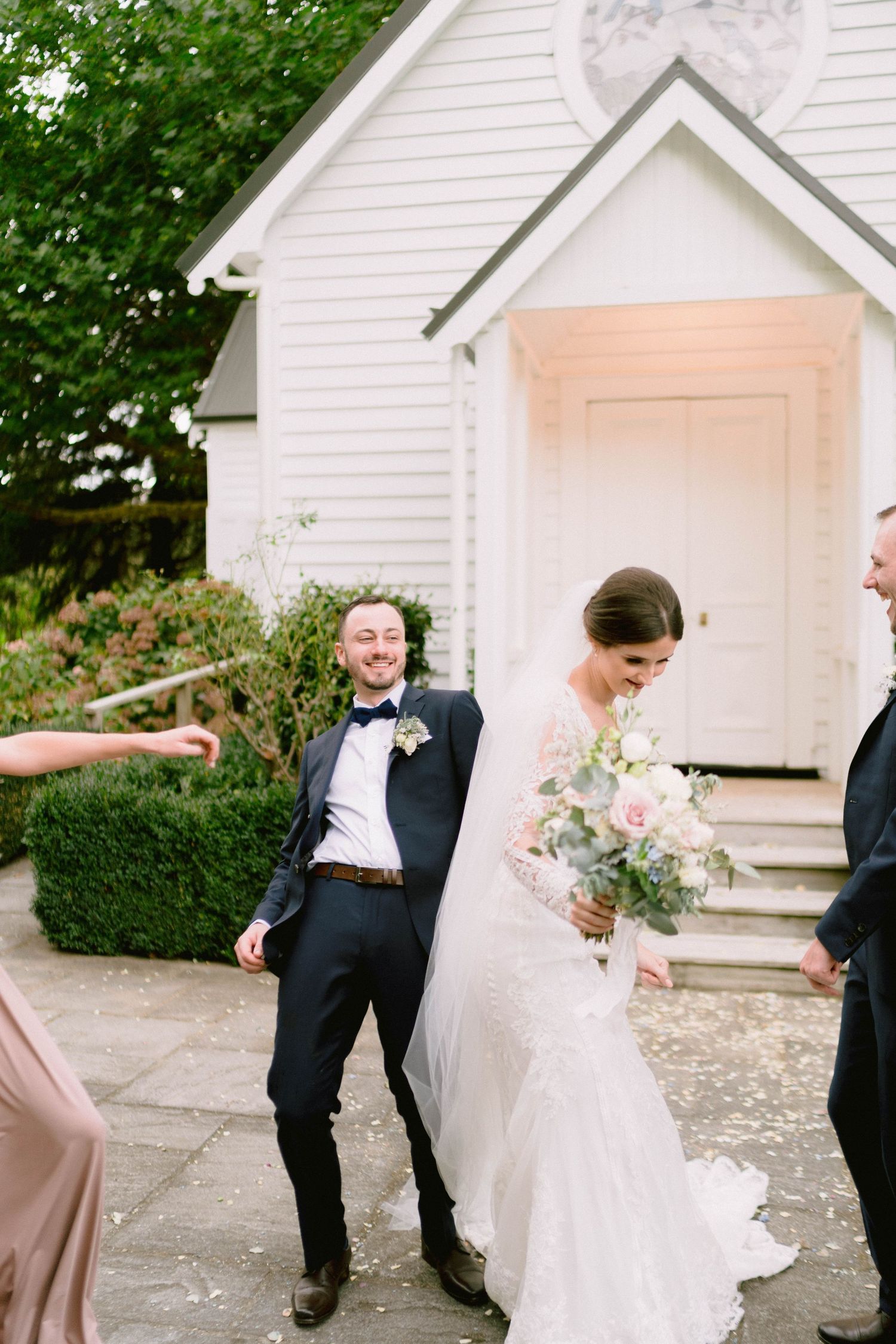 Newlyweds share a moment outside a charming white chapel.