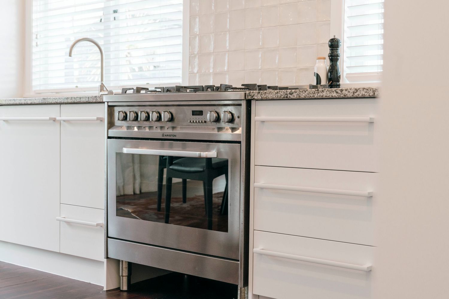 Contemporary white kitchen featuring stainless steel appliances and granite countertops.