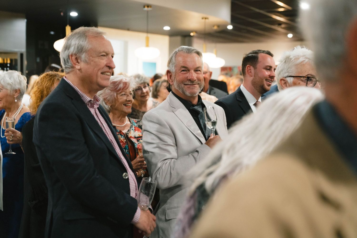 A candid shot of guests enjoying themselves at a formal evening celebration or reception.