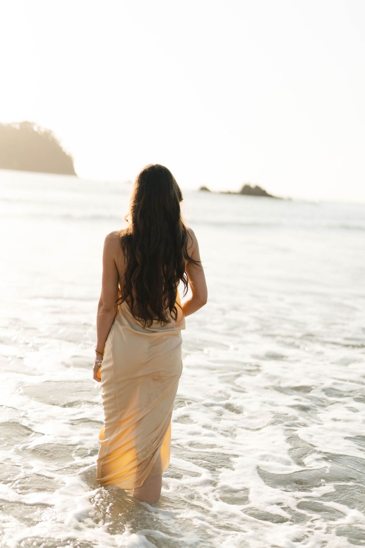 A dreamy sequence of photos showing a person wading into golden sunlit ocean waters at sunset.