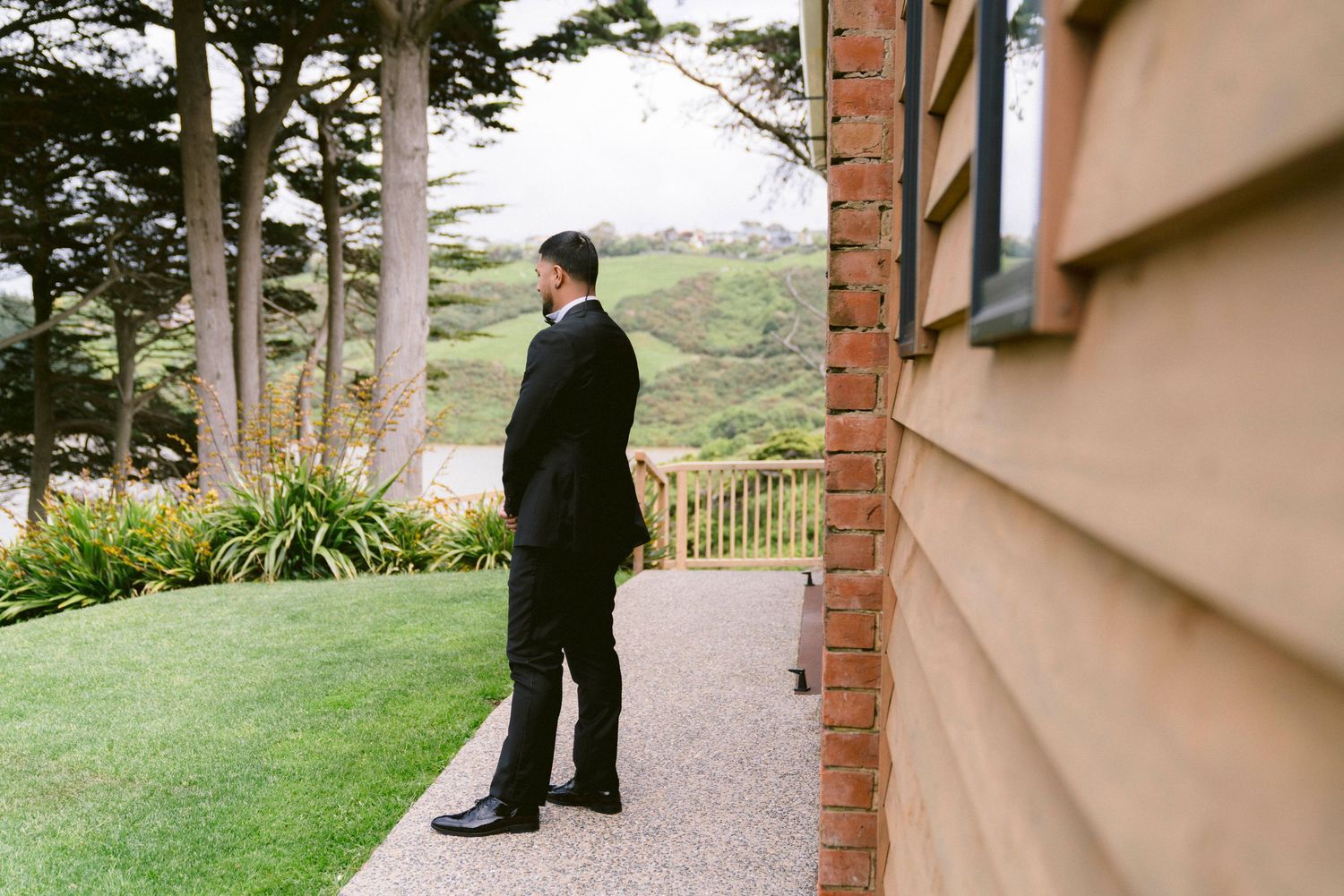 Couple taking wedding photos on a scenic outdoor path surrounded by trees.
