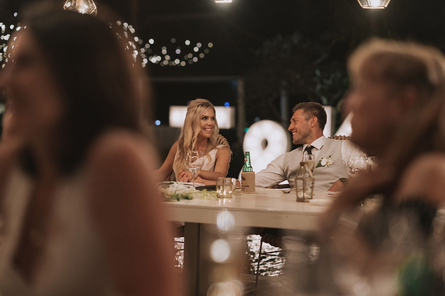 Candlelit wedding reception dinner captured through ambient bokeh lighting.