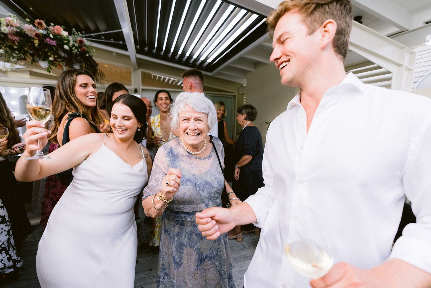 Wedding guests share a lively moment of dancing and laughter during the reception celebration.