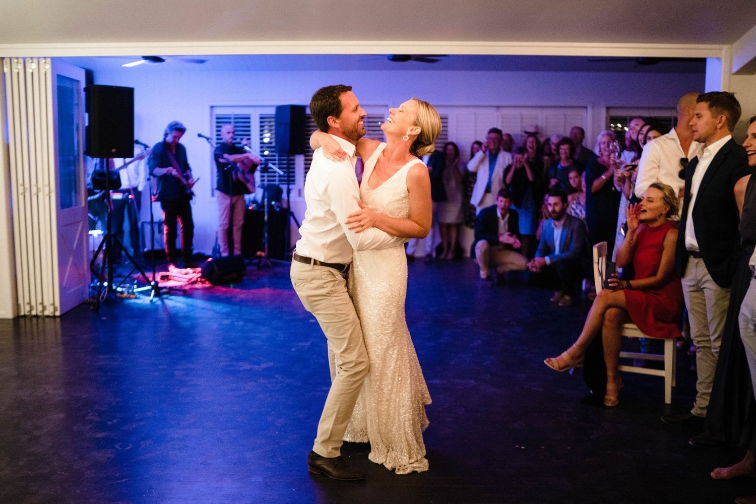 Wedding reception dance floor illuminated with purple lighting in an elegant indoor venue.