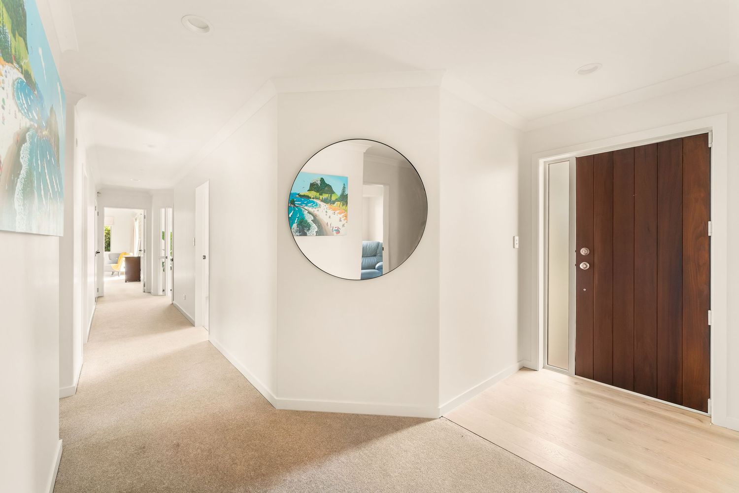 Open concept living space with white walls and large windows providing natural light.