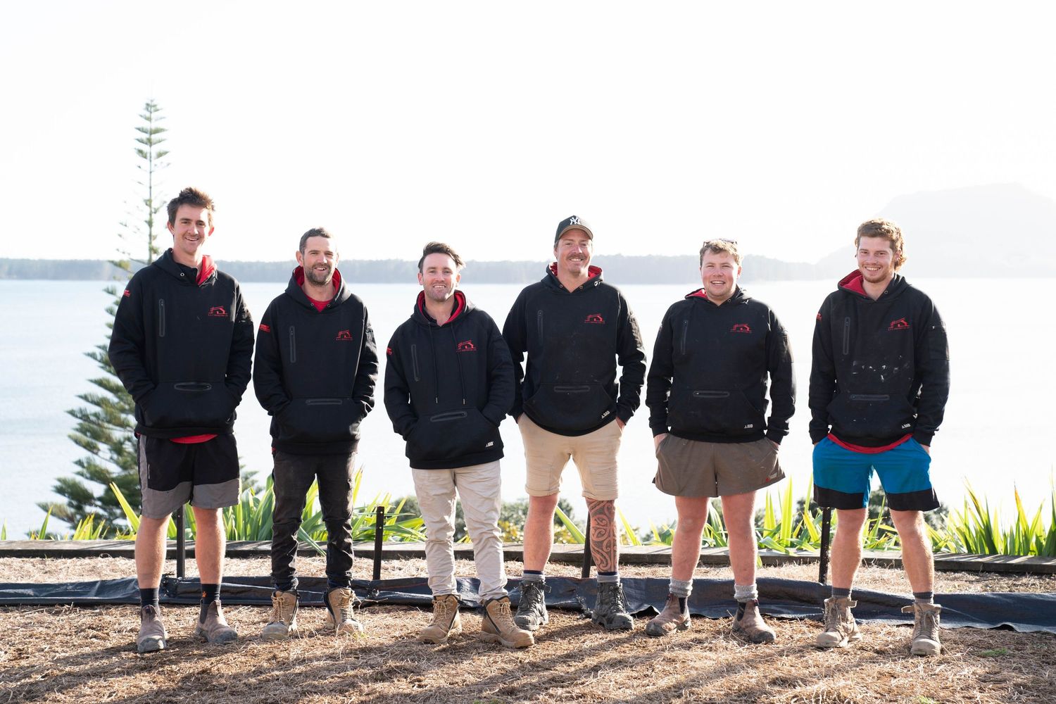 A series of construction workers sitting on concrete blocks against a white wall background.