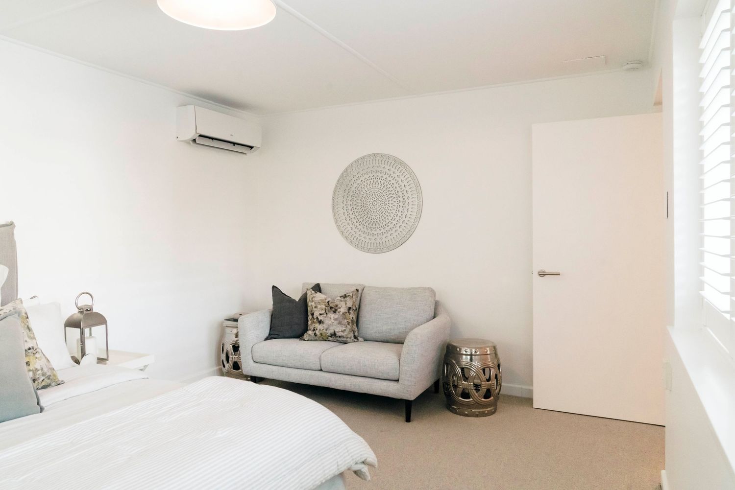 Bright and airy room with grey seating and modern lighting fixtures.