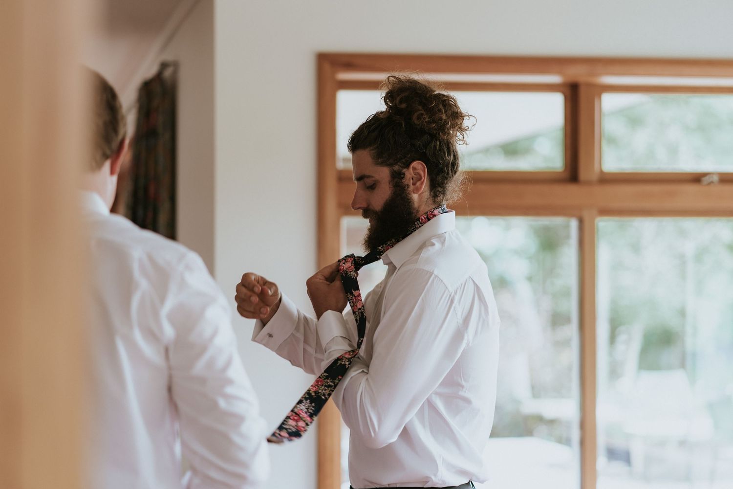 A couple in white attire performs traditional martial arts moves in a bright indoor space.
