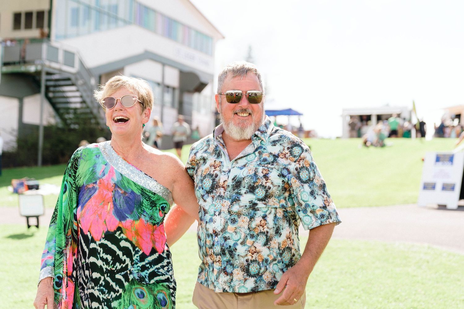 Guests in tropical print outfits mingling at an outdoor social gathering.