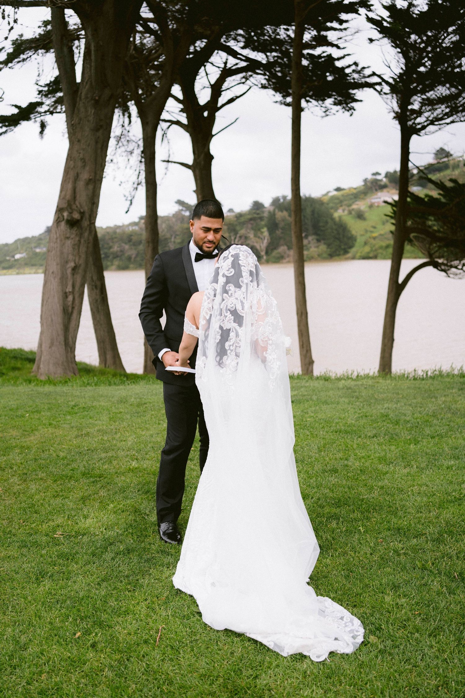 A series of romantic outdoor wedding photos showing a couple in formal attire among tall trees by a waterfront.
