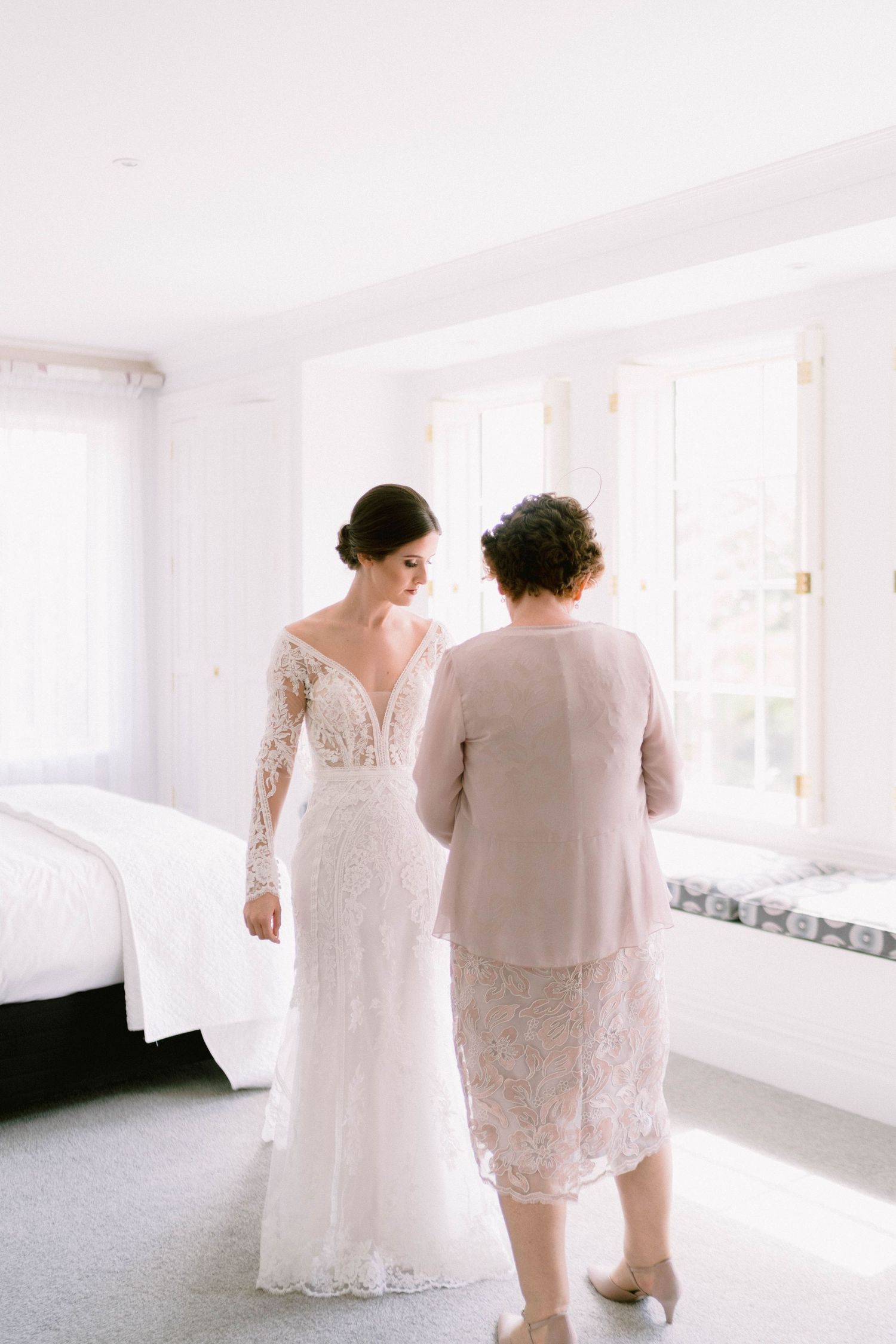 A progression of bridal photos showing the back view of a white lace wedding dress in a bright sunlit room.