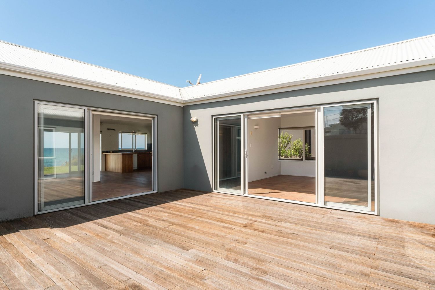 Outdoor wooden deck space with sliding glass doors connecting to interior living areas.
