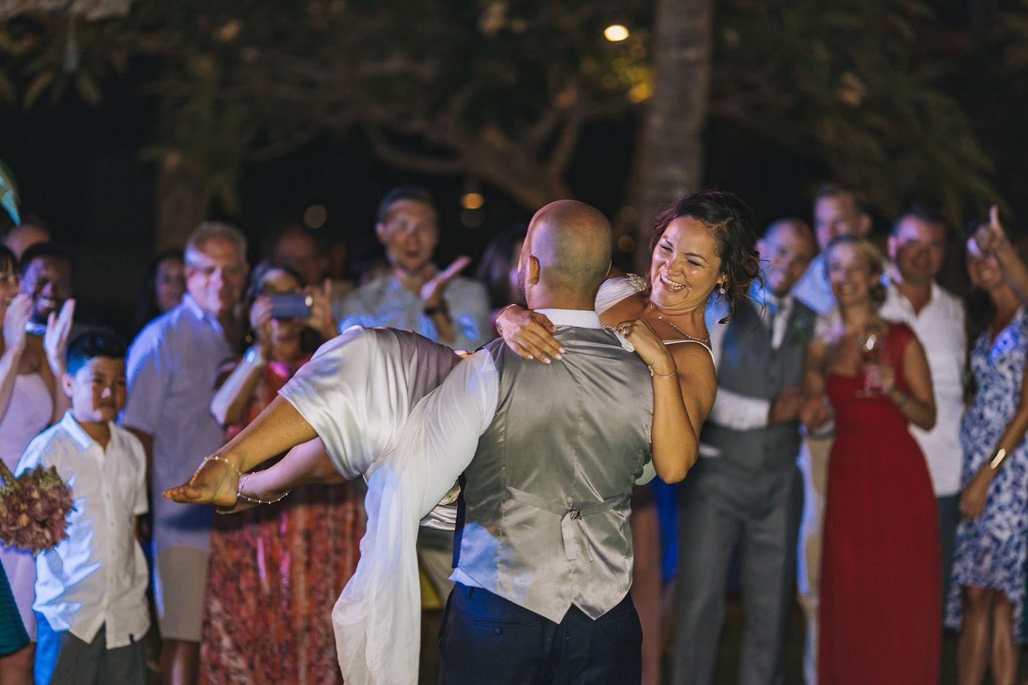 Elegant dance performance at outdoor evening wedding reception with crowd watching.