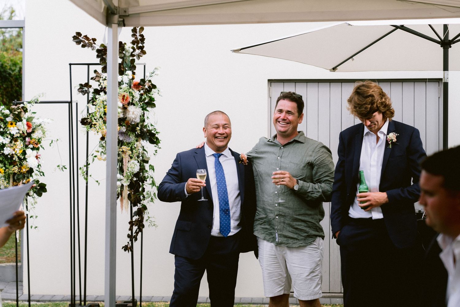 Casual pre-wedding gathering on a white patio with greenery decorations.