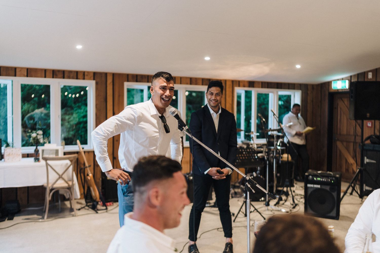 Wedding reception room with guests gathered around tables during an indoor celebration event.