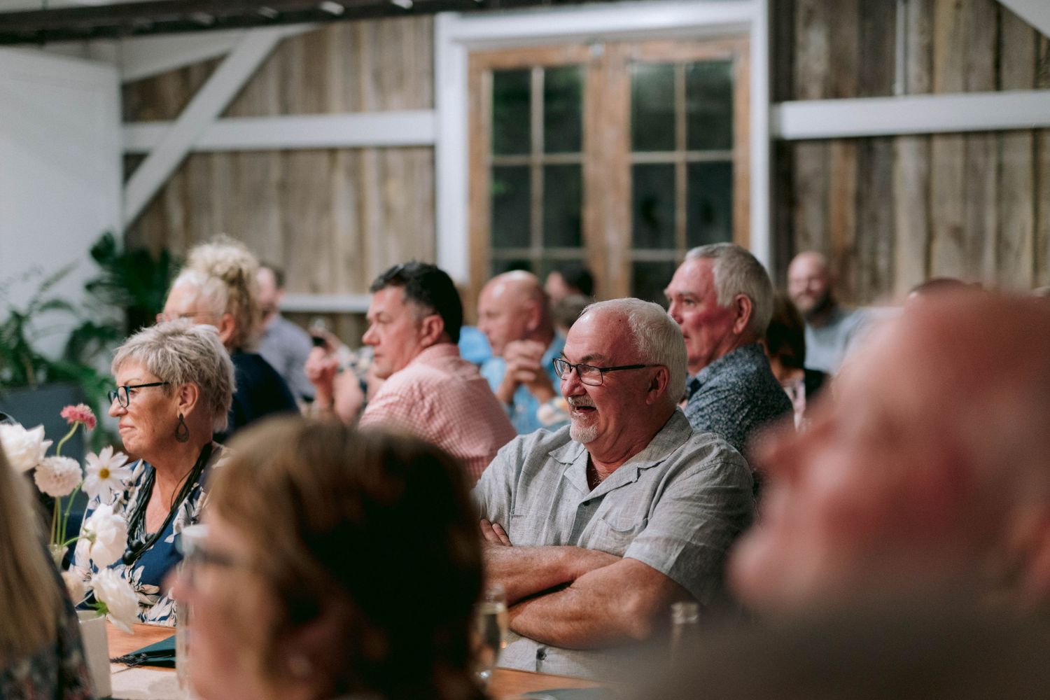 Wedding guests seated in rows watching an emotional ceremony moment.