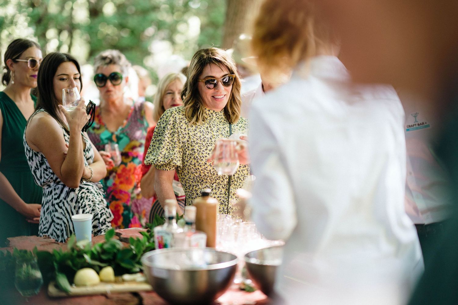 Wedding guests socializing at an outdoor reception buffet table.