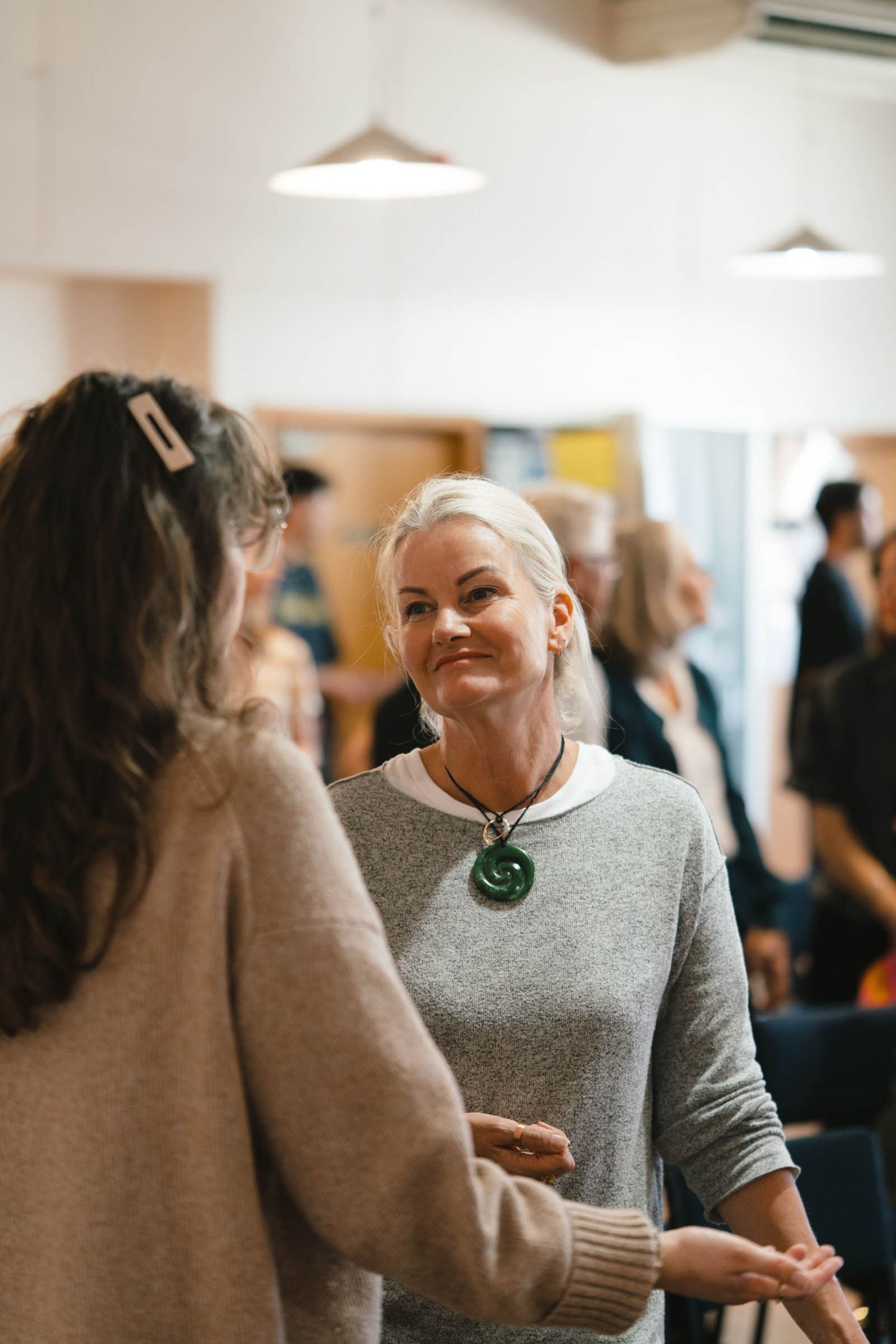 Two people having an animated conversation in a bright indoor space.
