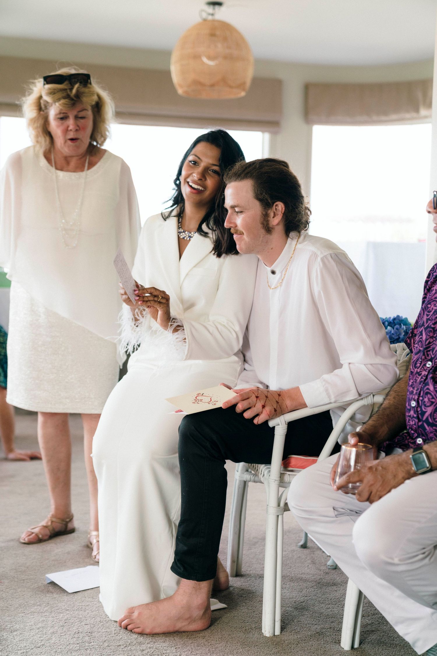 An intimate indoor wedding moment with guests sharing laughter during the ceremony.