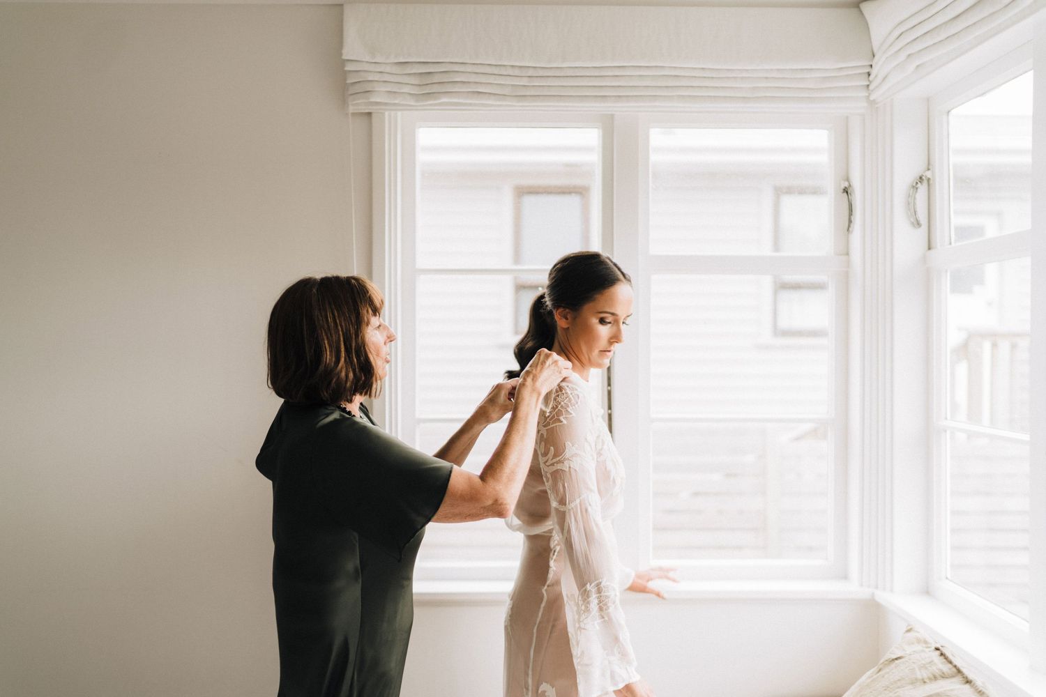 Romantic bridal preparations captured in a bright window-lit room with soft white tones.