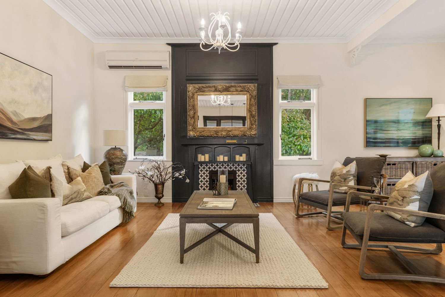 Bright open-concept living room with white walls, hardwood floors, and modern furnishings.