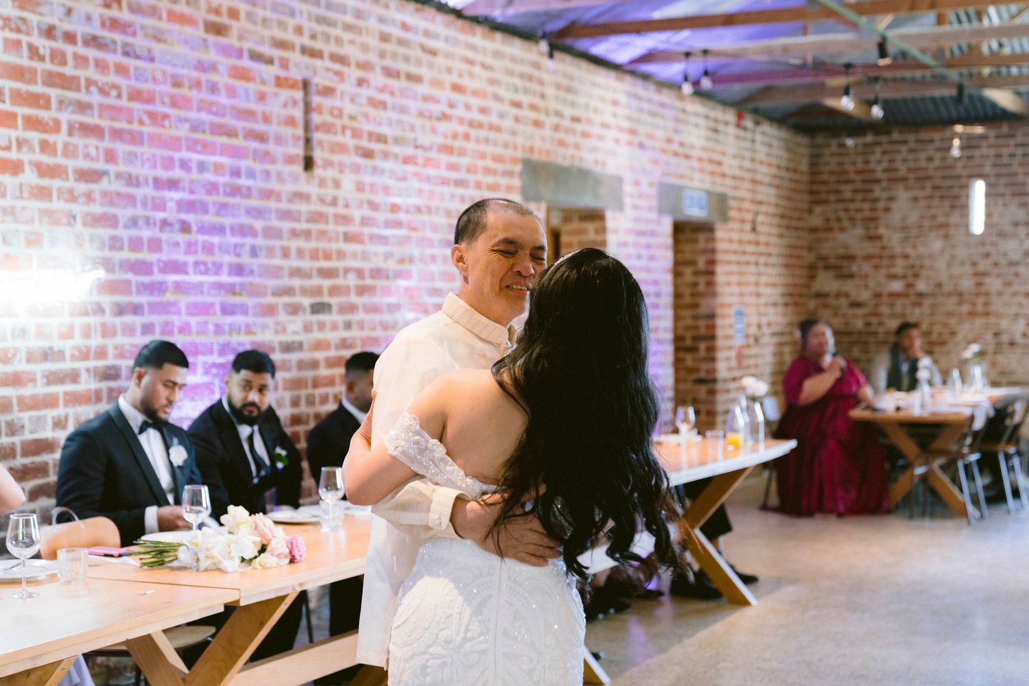 Dancing couple sharing a special moment at their wedding reception in an industrial-style venue.
