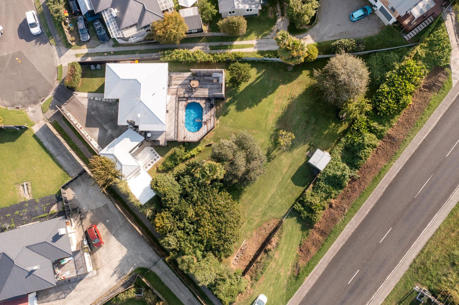 Aerial view of suburban houses and properties with green lawns and driveways.