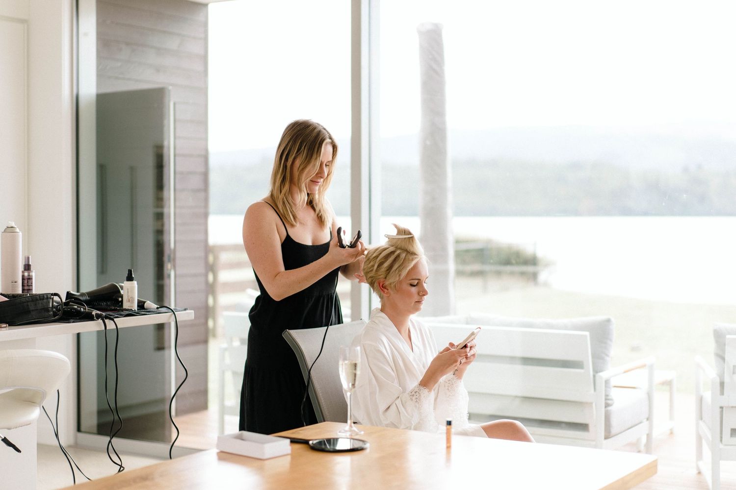 Modern bright interior space with hair styling setup and scenic window views.