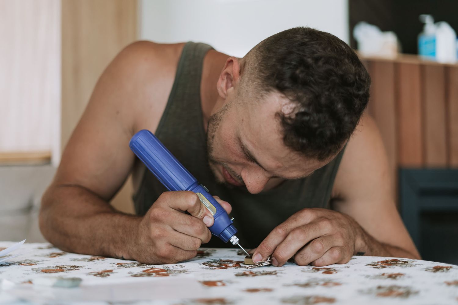 A person works on assembling a jigsaw puzzle at a wooden table, focusing intently on the pieces.