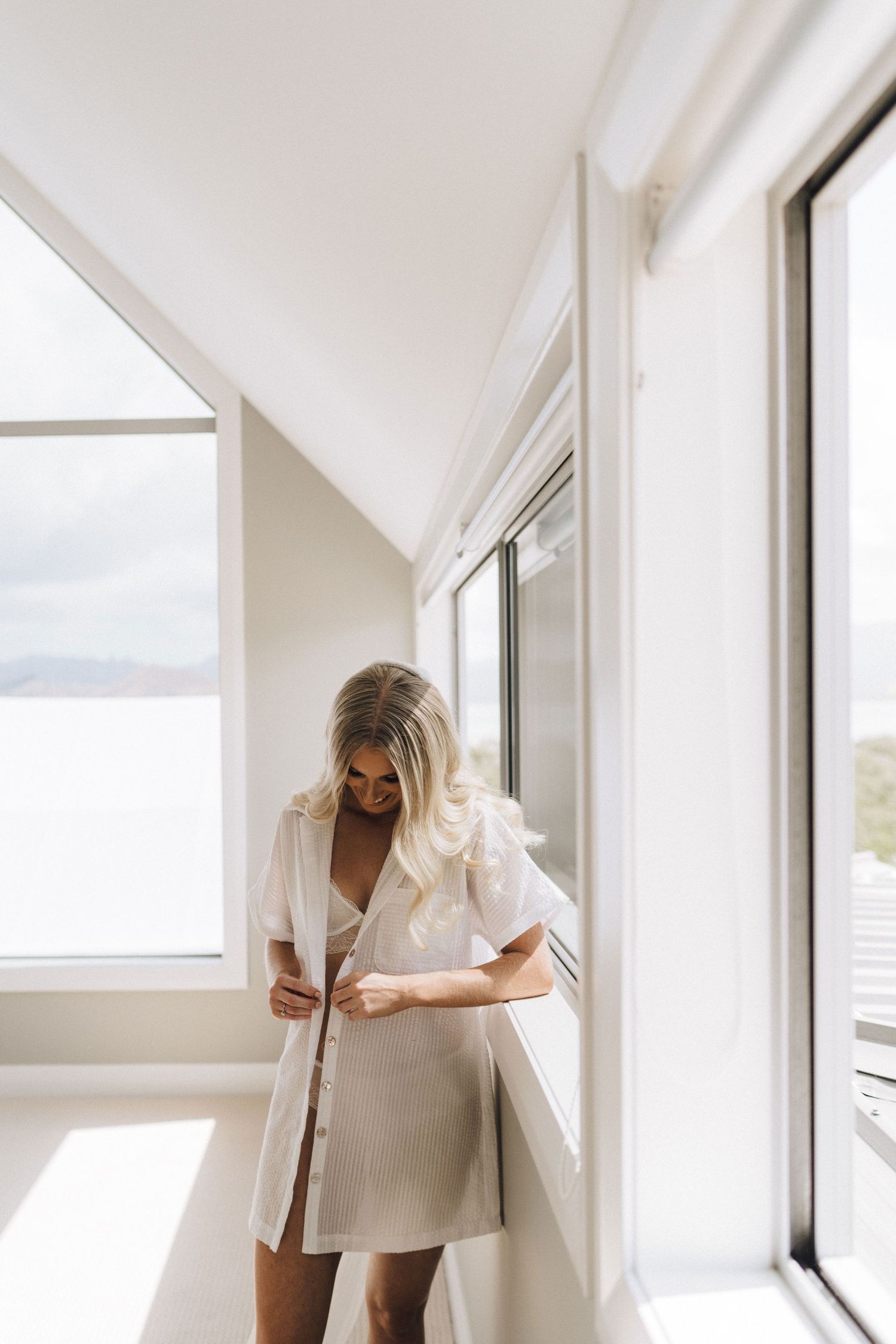 A series of window views showing a person in white clothing walking through an interior hallway space.