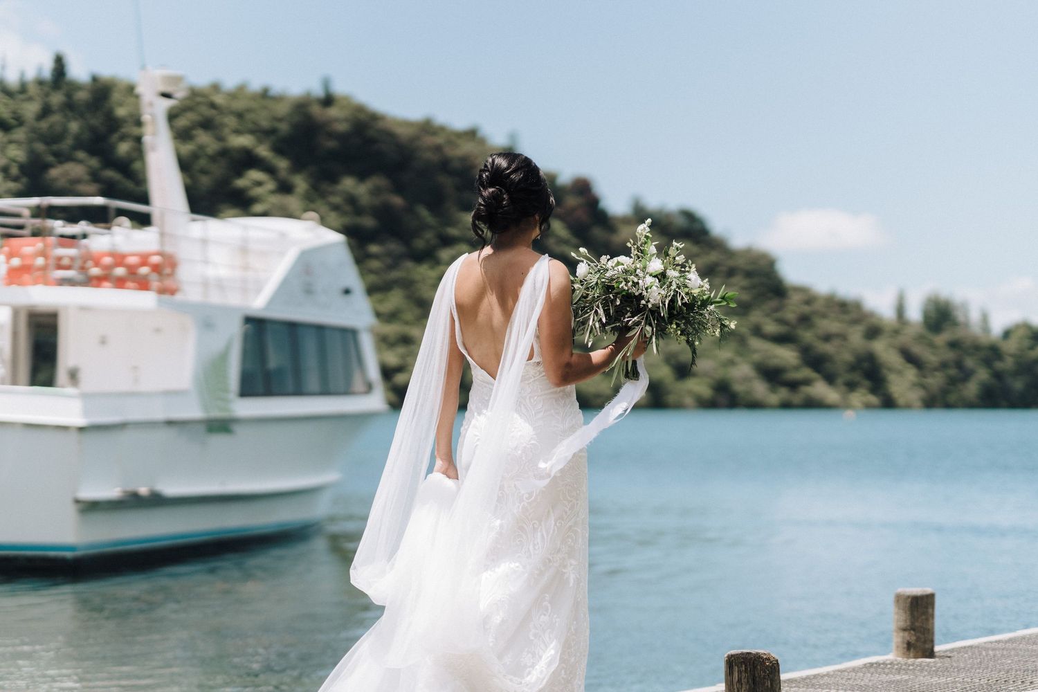A scenic waterfront wedding scene with docks, boats, and coastal decor against a blue lake backdrop.