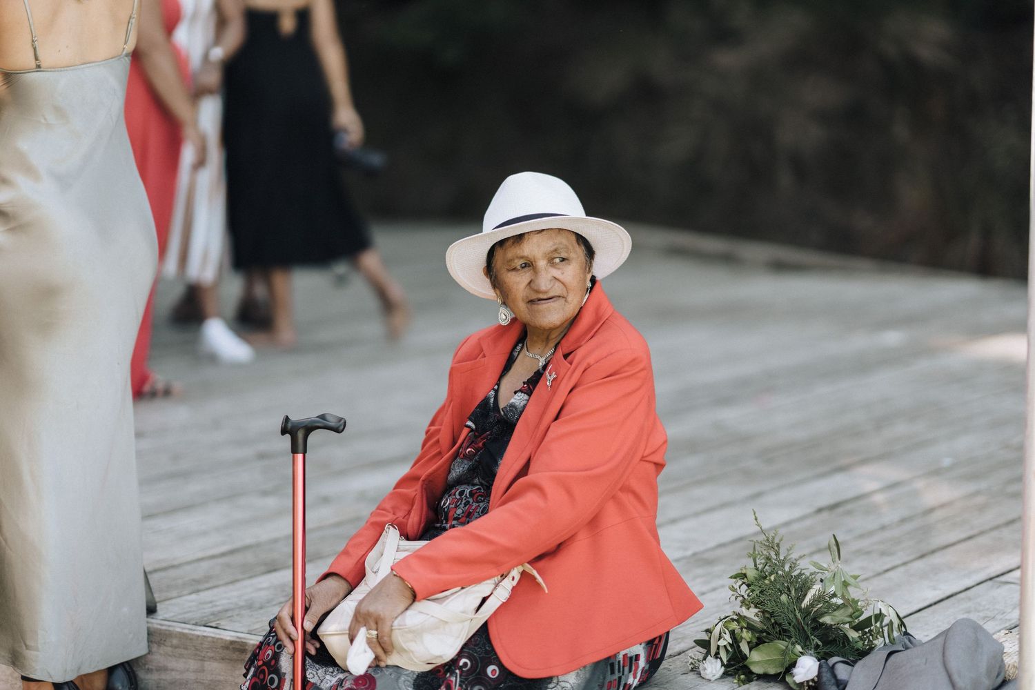 Guests in coral attire enjoying outdoor wedding festivities.
