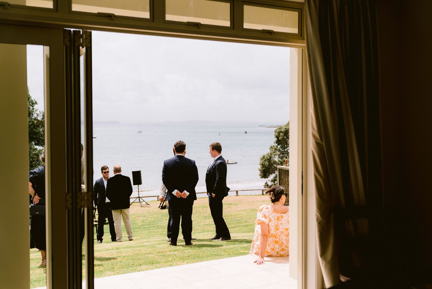 Interior view of an elegant venue with large windows overlooking a waterfront setting.