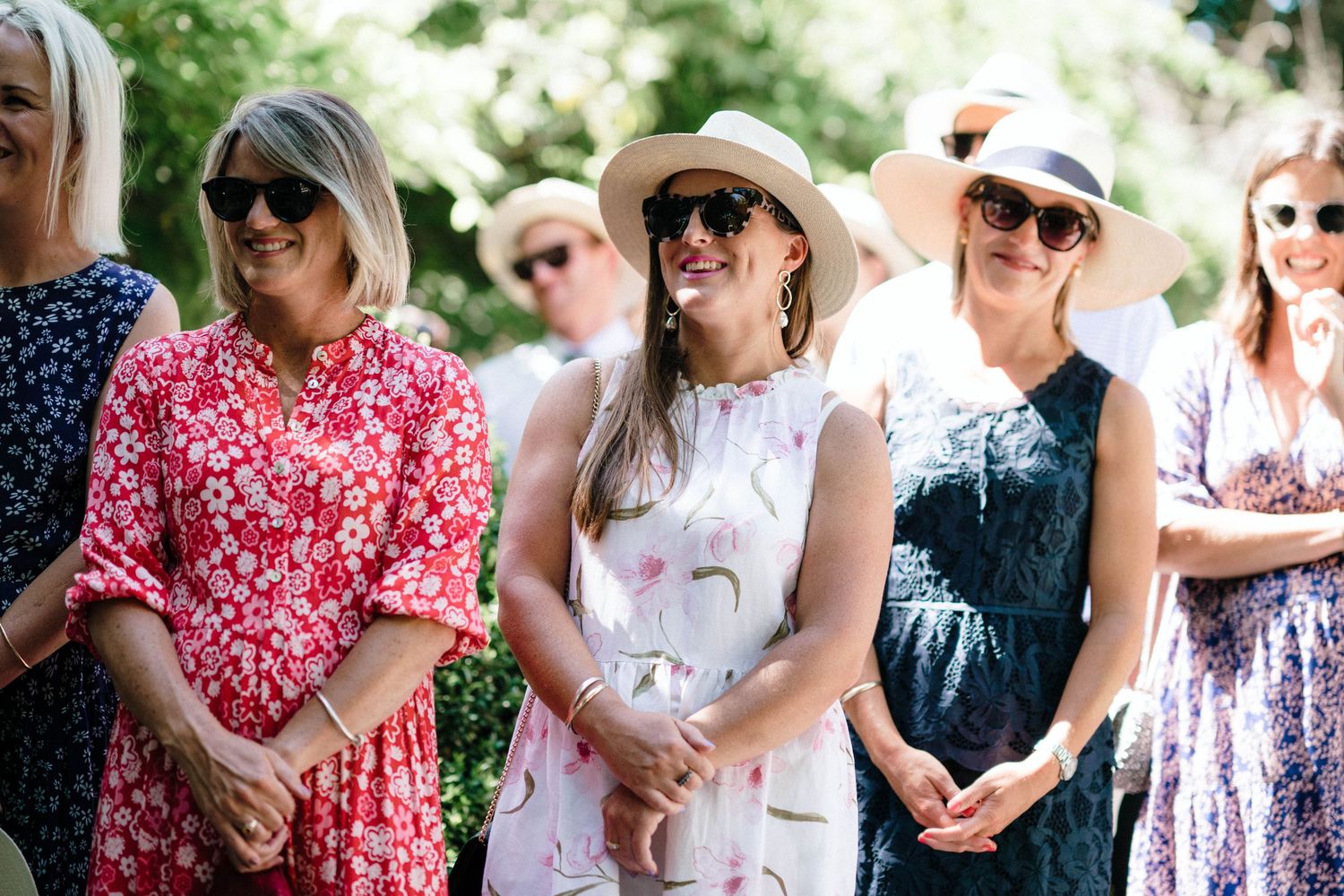 People gathered casually outdoors in summer clothing enjoying a social event in natural lighting.