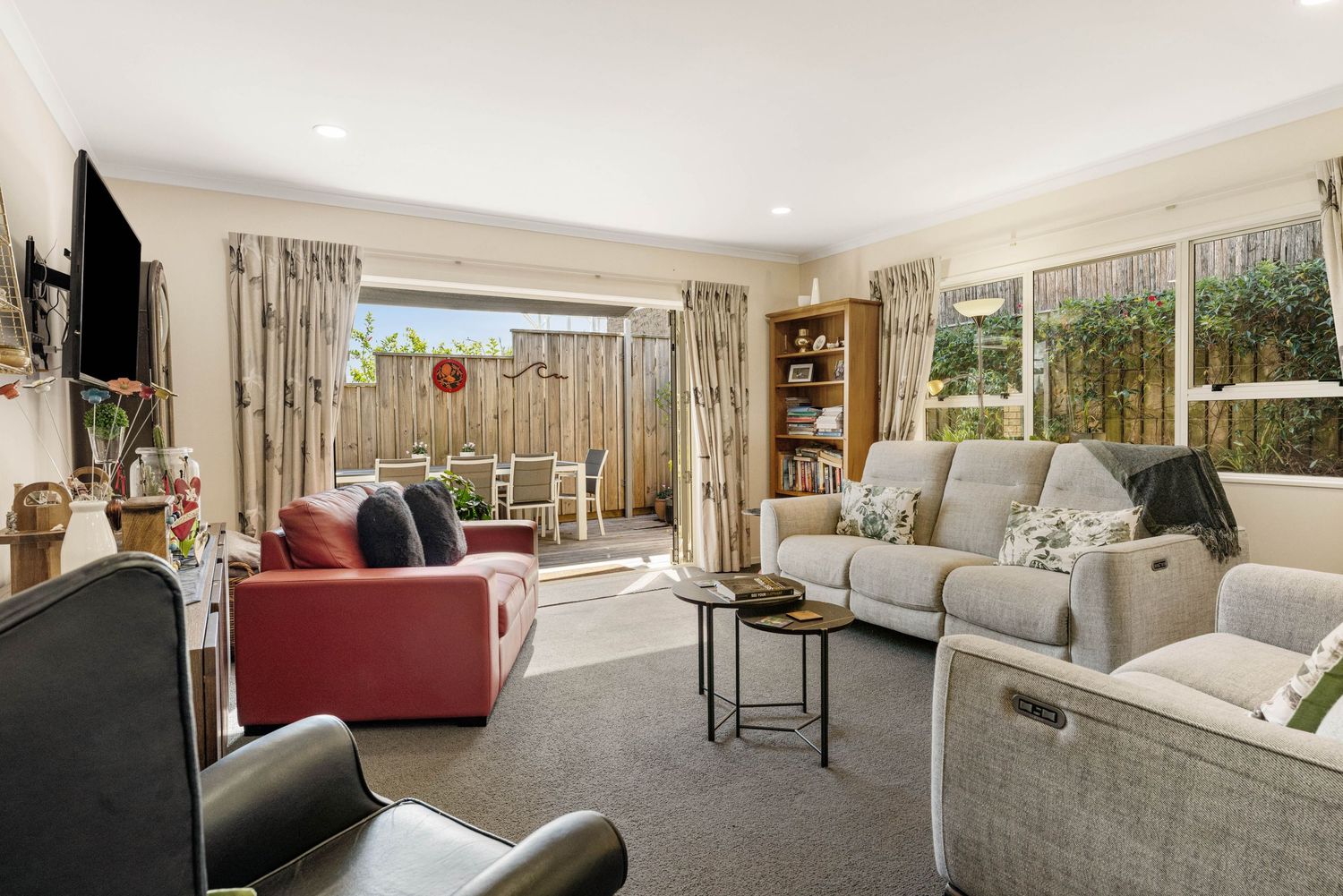 Modern living room interior with neutral tones showcases plush seating and large windows offering abundant natural light.