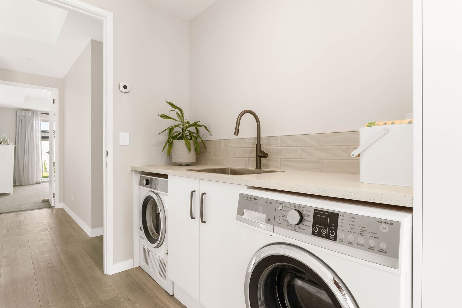 White laundry room with modern appliances and clean minimalist design.