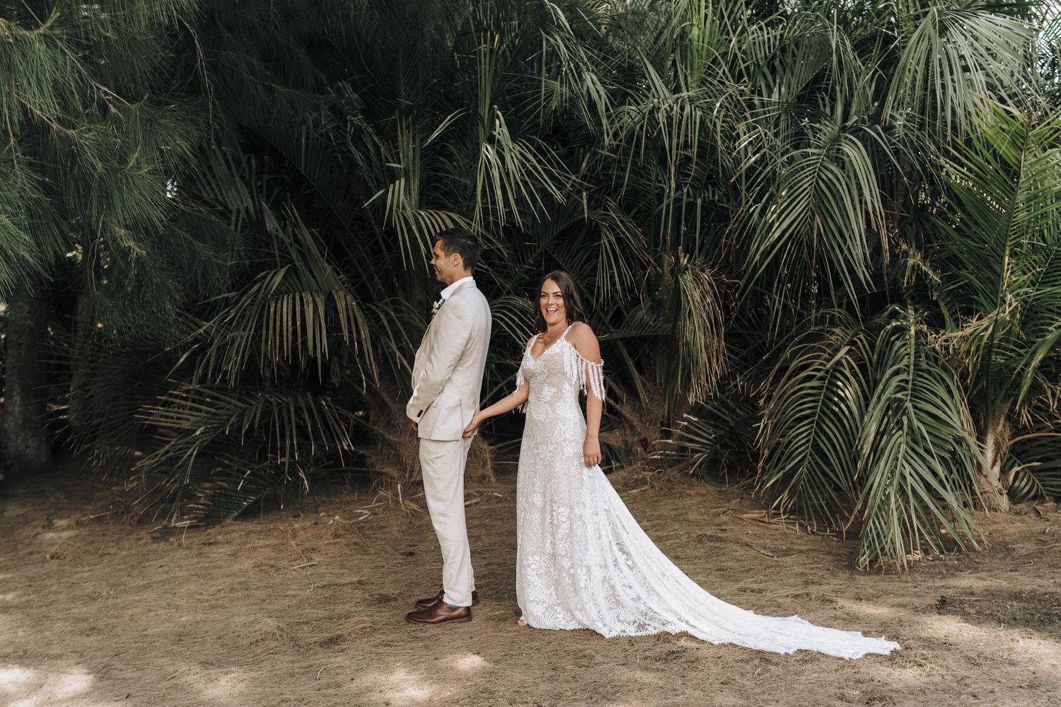 Outdoor wedding photography session among tropical palm trees and natural scenery.
