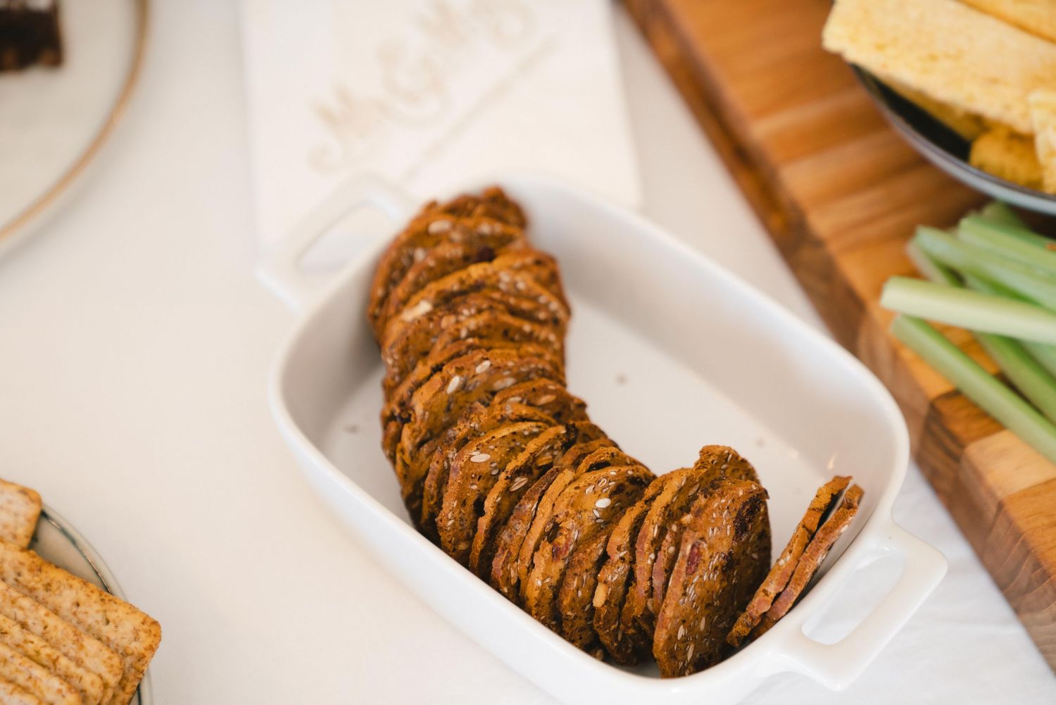 Sliced rustic bread arranged in a curved line on a white serving plate.