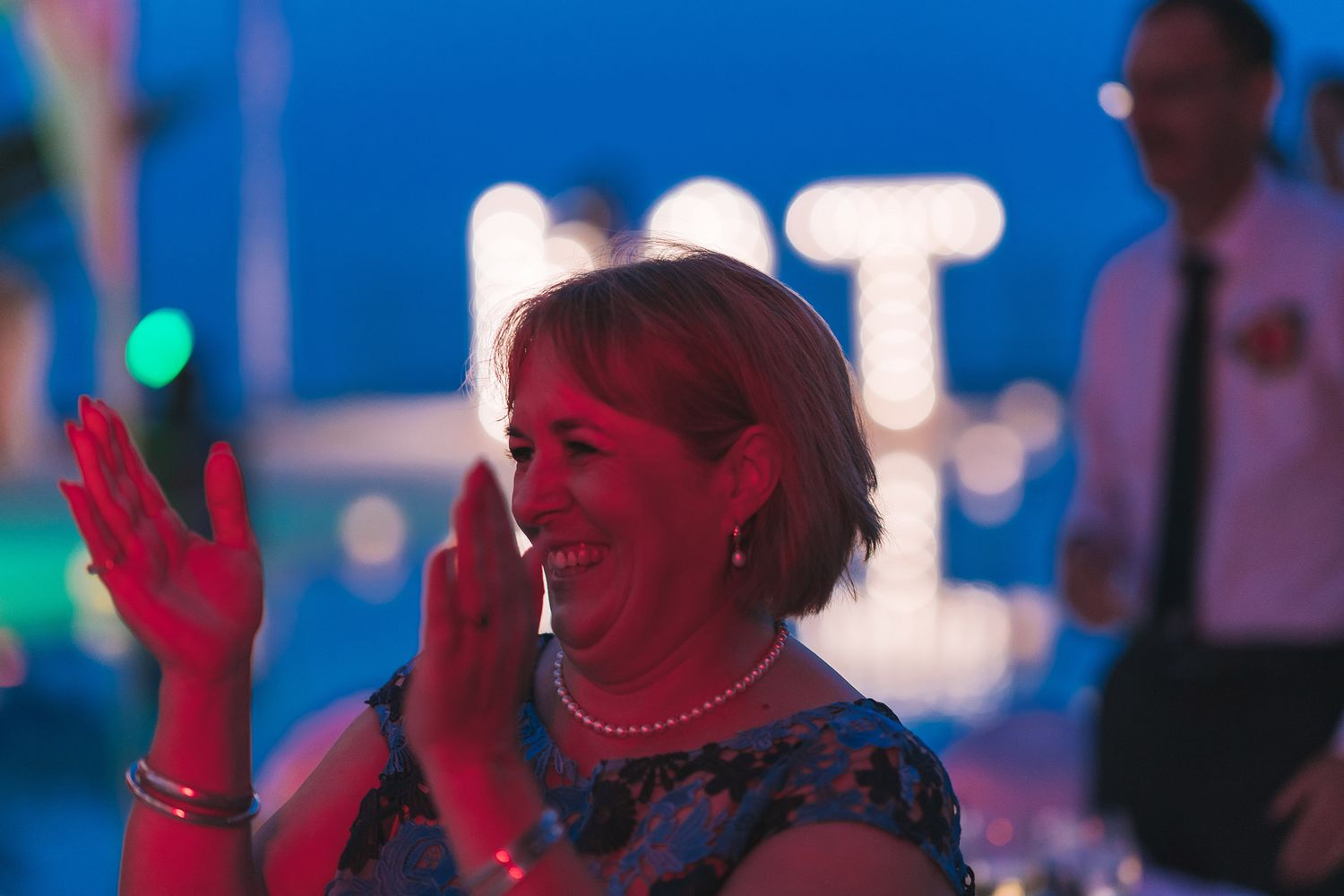 Wedding reception dance party with colorful mood lighting.