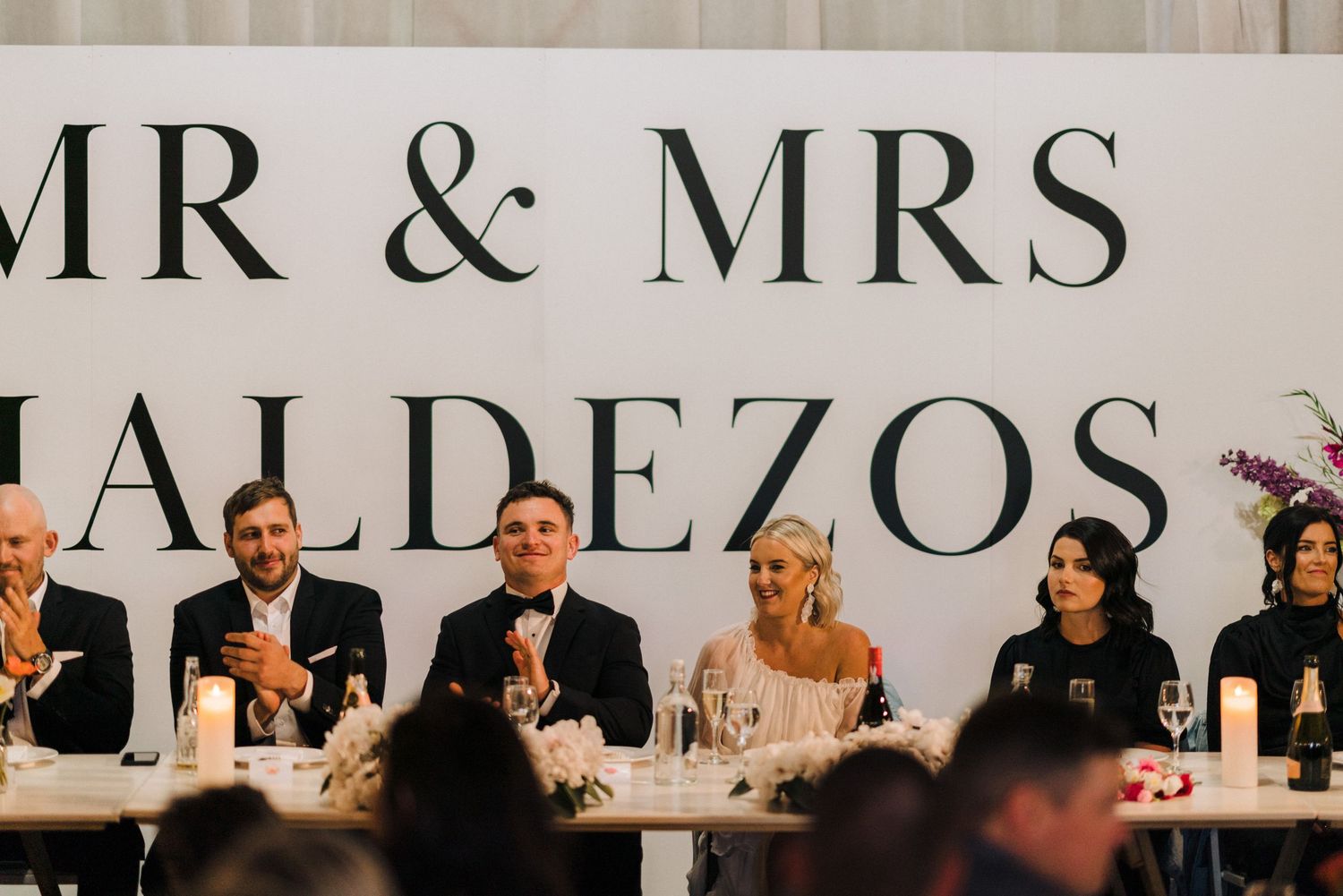 A wedding reception venue decorated with elegant 'MR & MRS' signage and table settings.