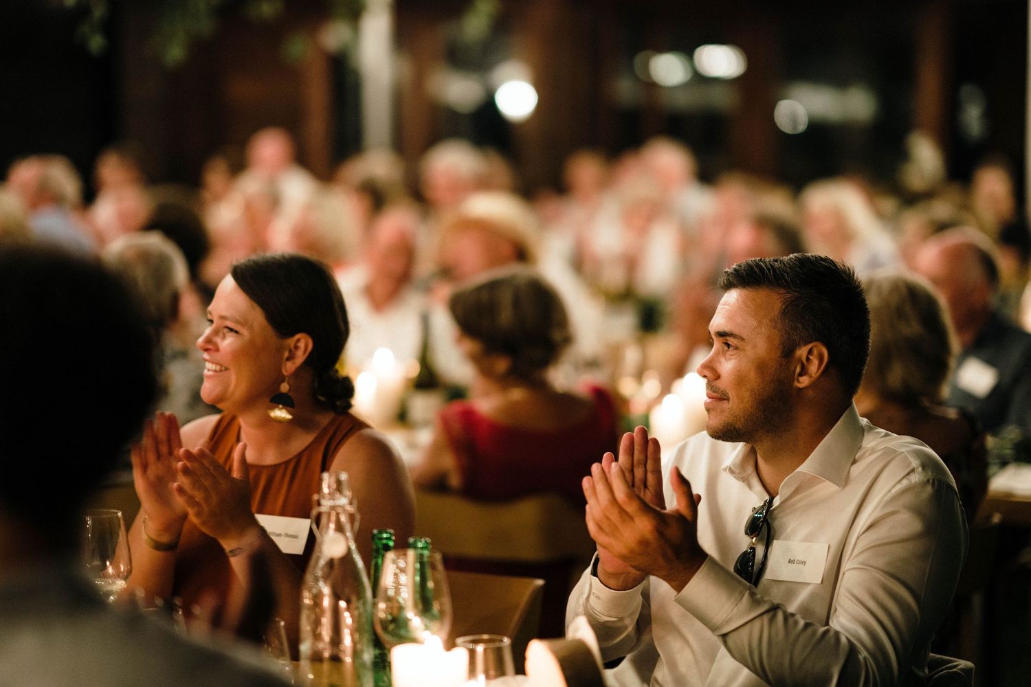 Wedding guests laughing and enjoying themselves during an evening reception.
