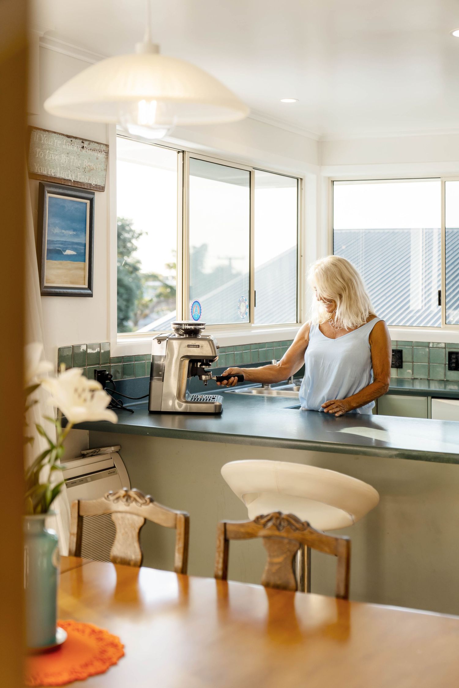 Bright open-concept kitchen and dining area with panoramic windows offering stunning ocean views.