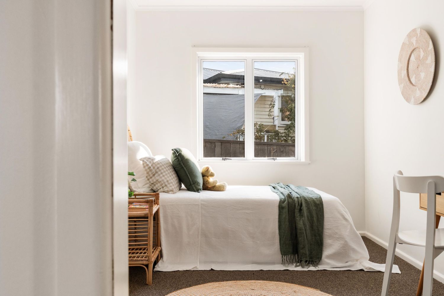 Minimalist white interior room with windows and natural light streaming in.