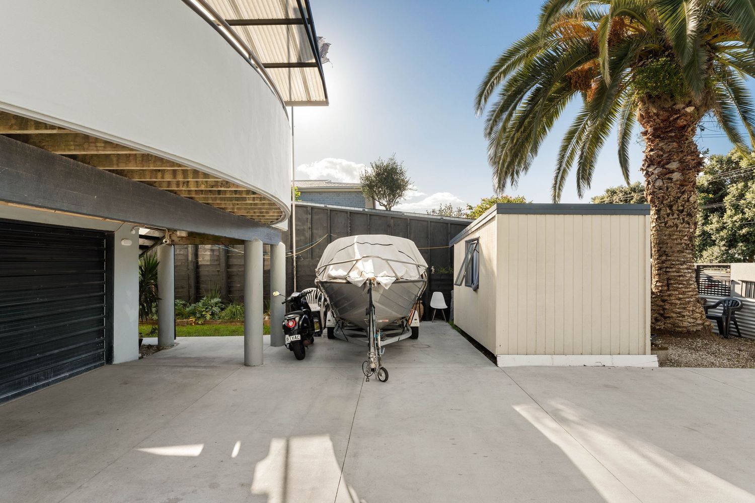Large boat storage area under covered carport with ample space for vehicles.