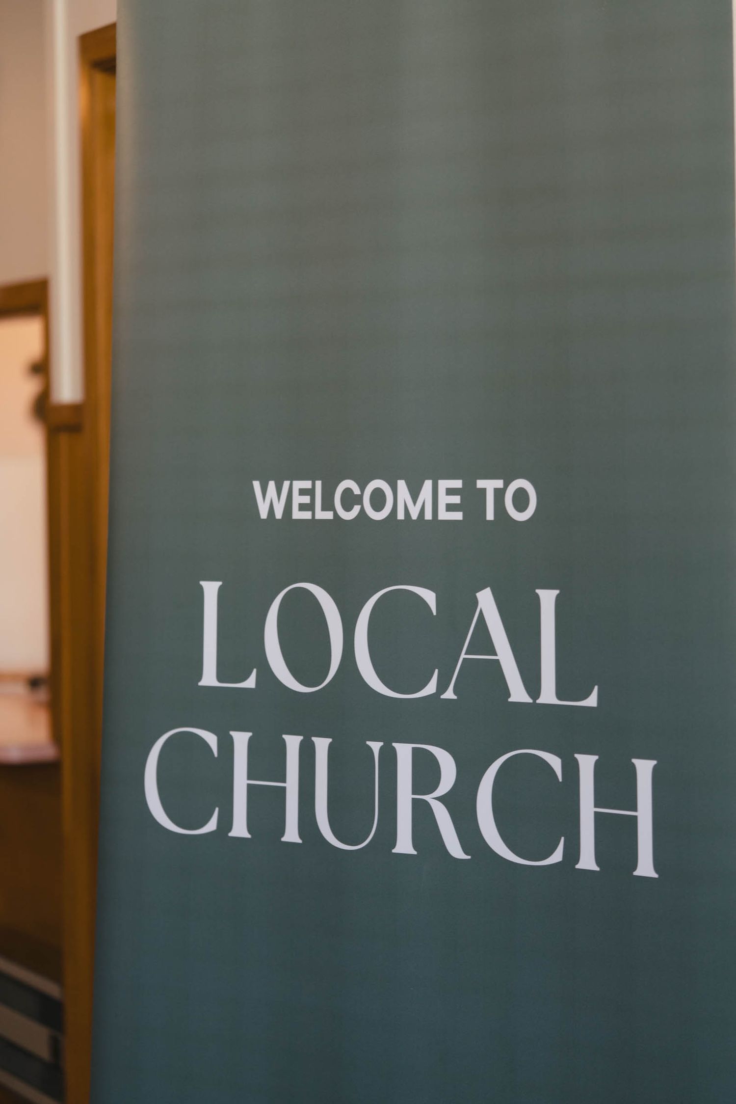 A green wall sign reading 'Welcome to Local Church' in white text against a minimalist background.
