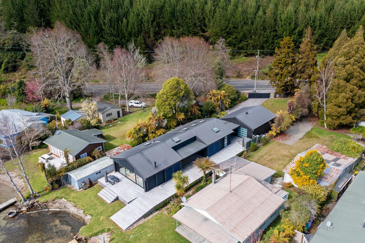 Aerial view of modern suburban homes with solar panels and landscaped yards surrounded by autumn trees.