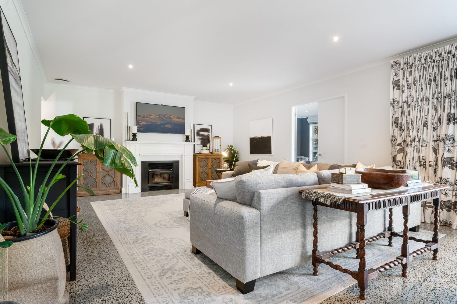 Contemporary living room with grey sectional sofa, fireplace and modern decor accents.